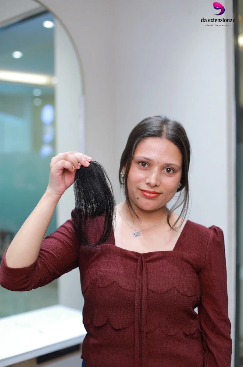 A length of removed human hair extension held up inside the DA Extensionzz studio, Chennai